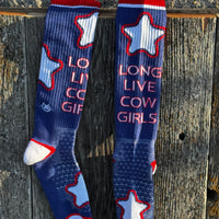 Pair of socks with star design and 'Long Live Cow Girls' text on a wooden surface