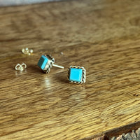 Pair of turquoise earrings on a wooden surface