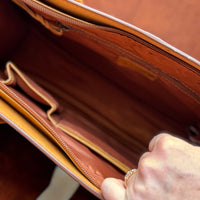 Showing interior of briefcase, with one small zippered pouch on one side and two small open pockets on the other side