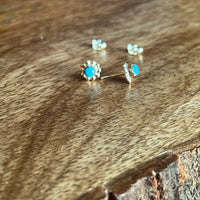 pair of turquoise and silver earrings on wooden background