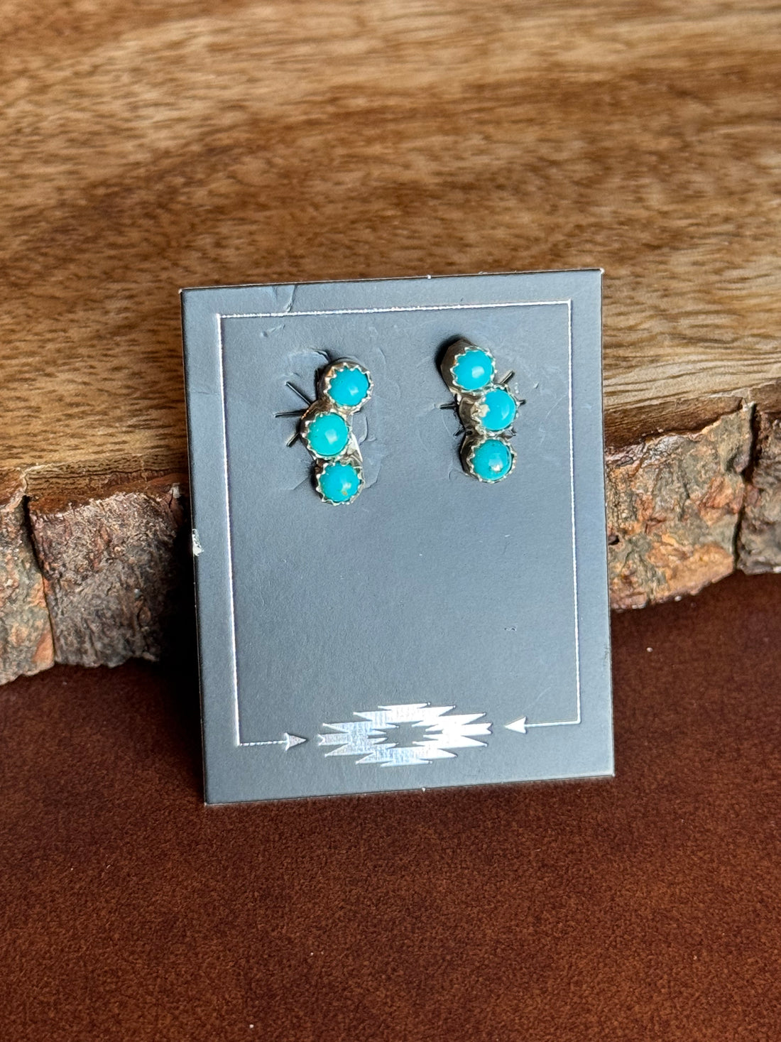 3 dot turquoise stone earrings on black card against wooden background