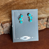 3 dot turquoise stone earrings on black card against wooden background