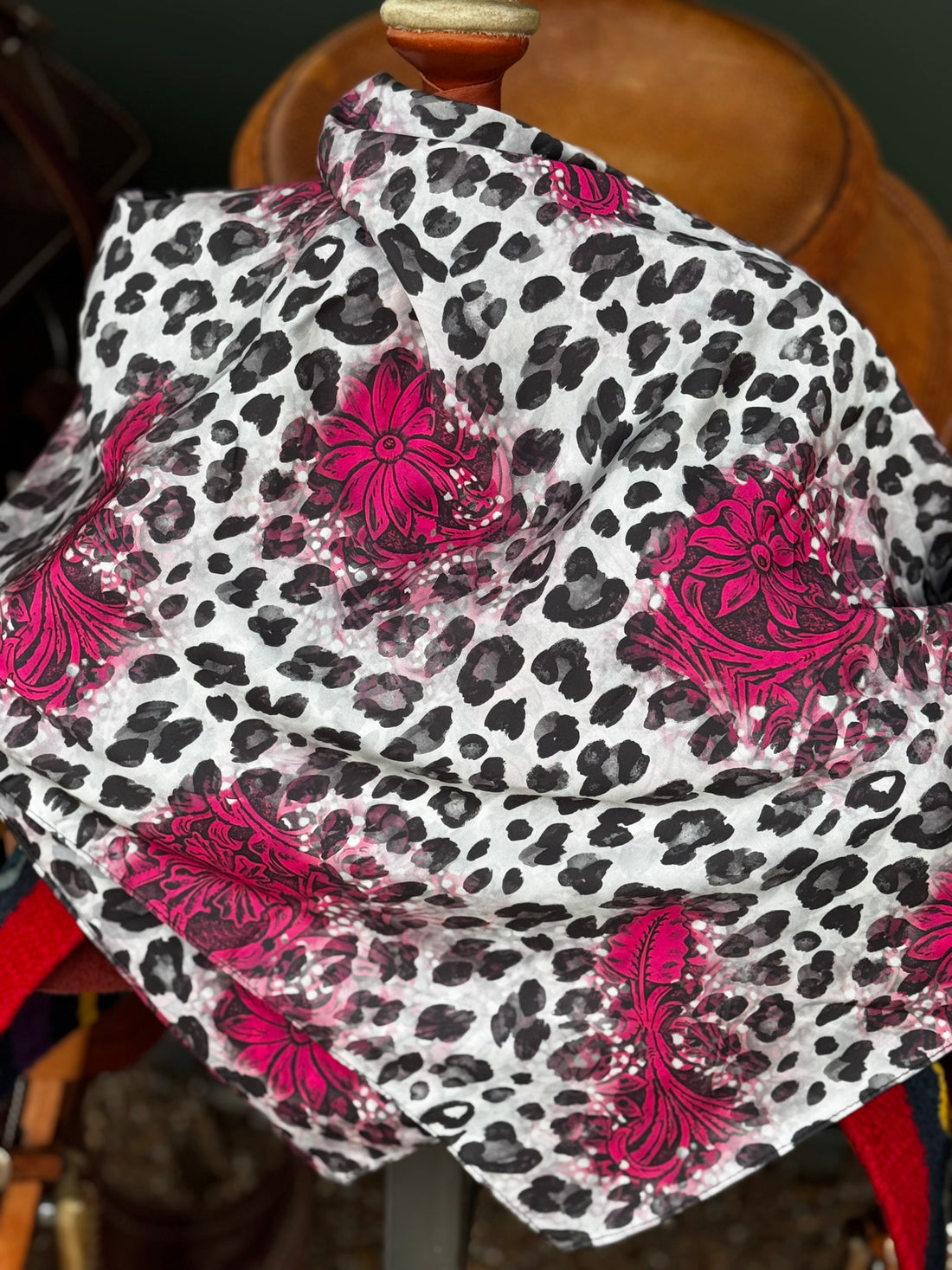 Leopard print fabric with pink floral patterns draped over a saddle