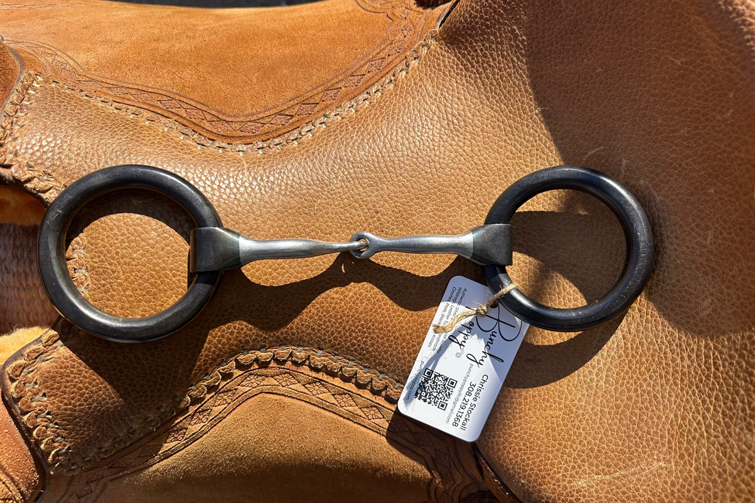 extra thick weighted ring smooth mouth snaffle laid across saddle seat