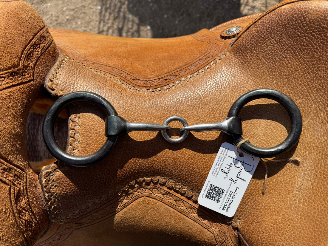 extra thick weighted ring snaffle with lifesaver laid over saddle