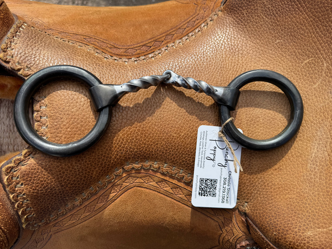 extra thick weighted ring snaffle with square twist mouth laid across saddle