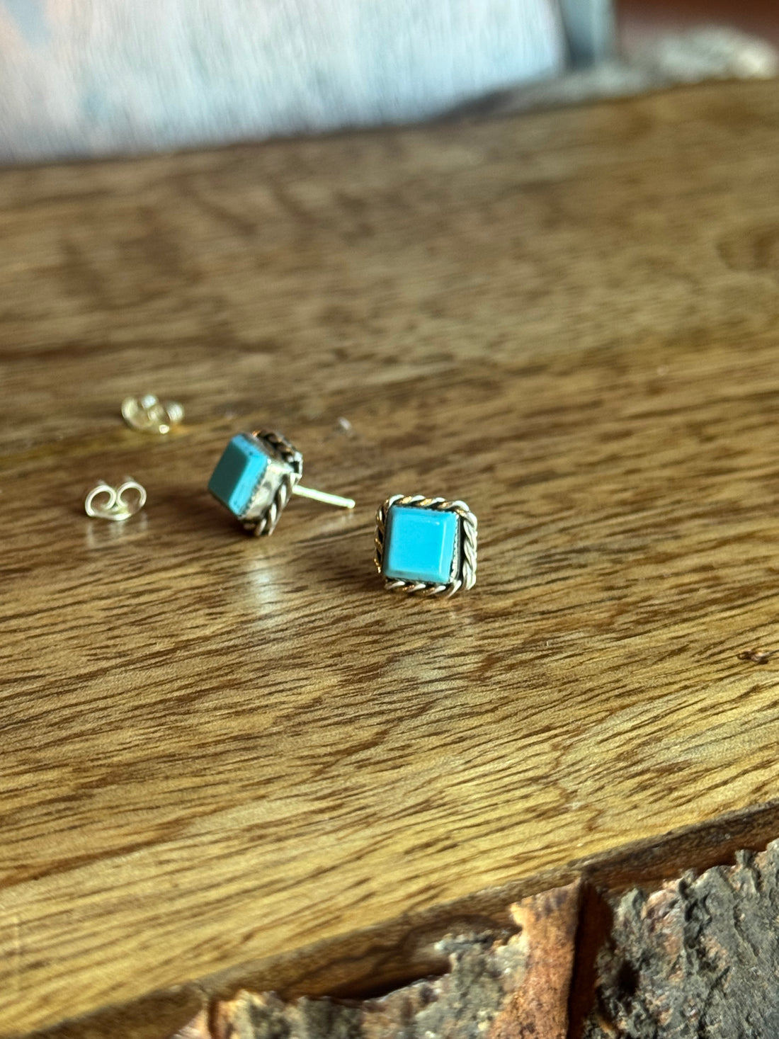 Pair of turquoise earrings on a wooden surface
