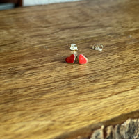 Red heart-shaped earrings on a wooden surface