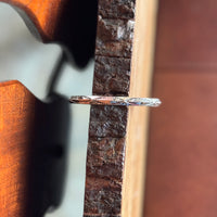Close up of stamped silver bracelet on wooden surface