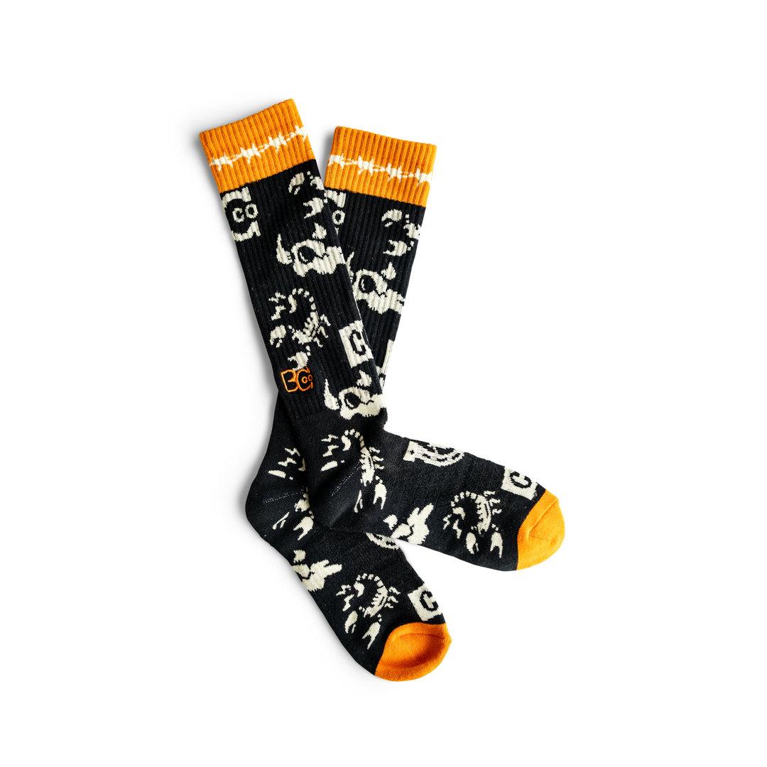 Black socks with orange accents, and white steer heads, scorpions and horse shoes, and  white barbed wire around tops